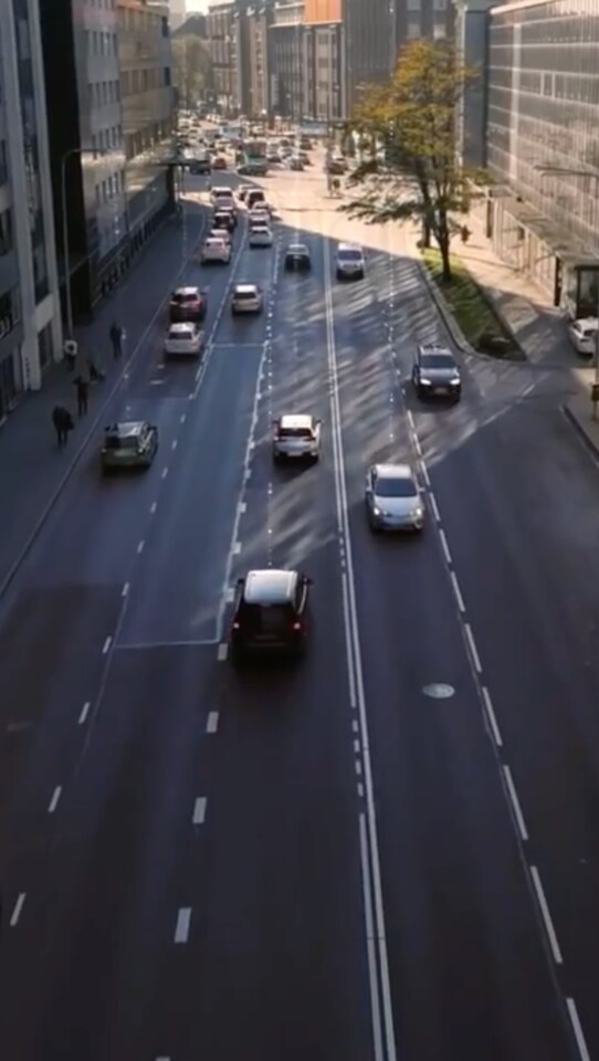 建物が立ち並び、多くの車が通り過ぎる往復5車線の道路