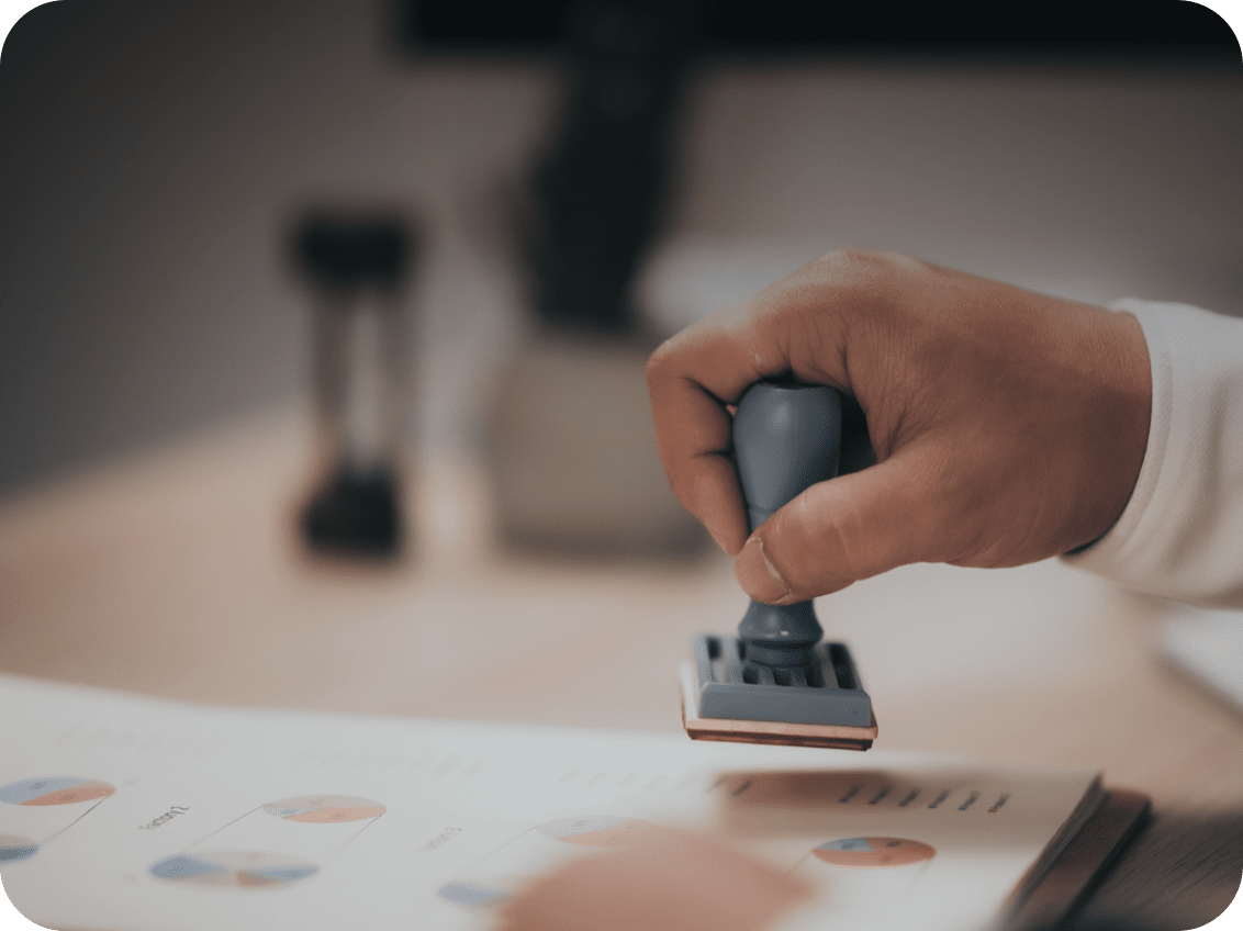 A close-up image of a hand stamping a document.