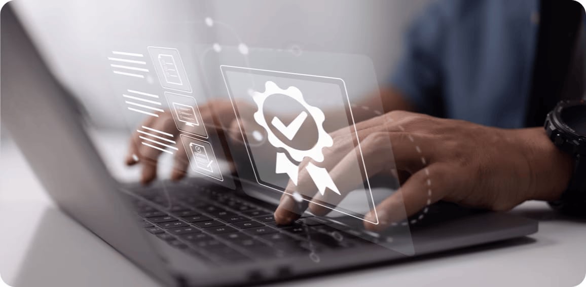 Image of digital authentication badge and icons floating above hands typing on laptop